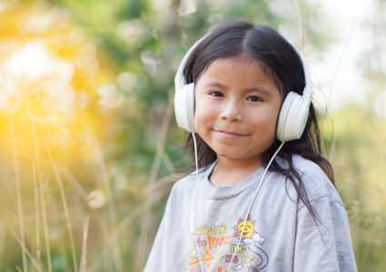Nations One girl smiling listening to radio