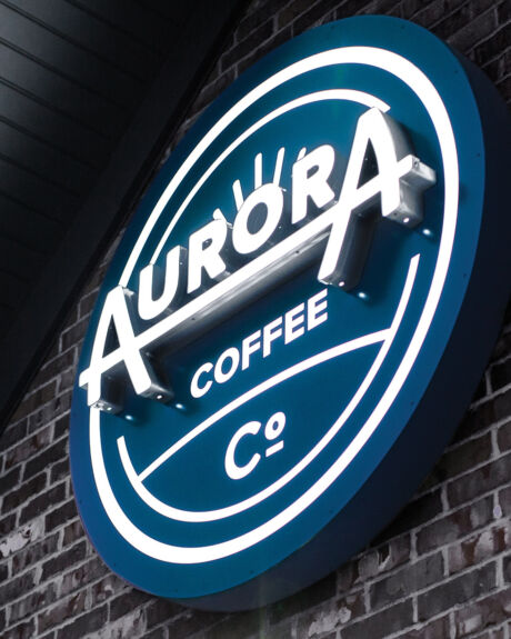 Signage designed as part of an overall brand identity system for Aurora Coffee Co., with multiple locations in the Cedar Rapids/Marion areas. Aurora Coffee Co. sign