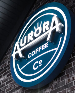 Signage designed as part of an overall brand identity system for Aurora Coffee Co., with multiple locations in the Cedar Rapids/Marion areas. Aurora Coffee Co. sign