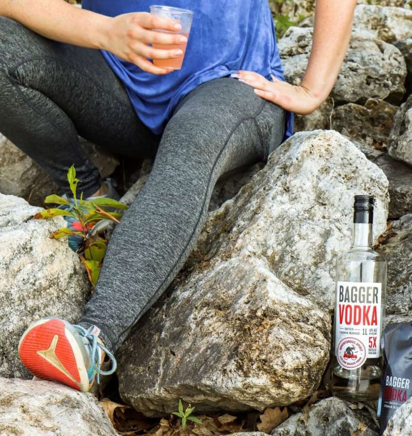 Person enjoying Bagger Vodka during a hiking respite